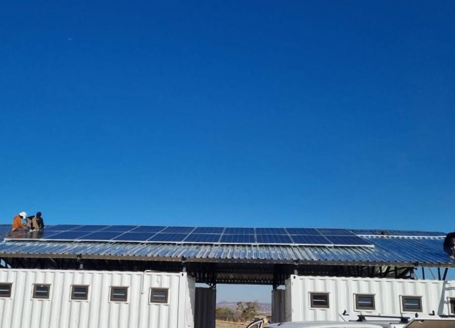 Solar array on a low building roof under a blue sky