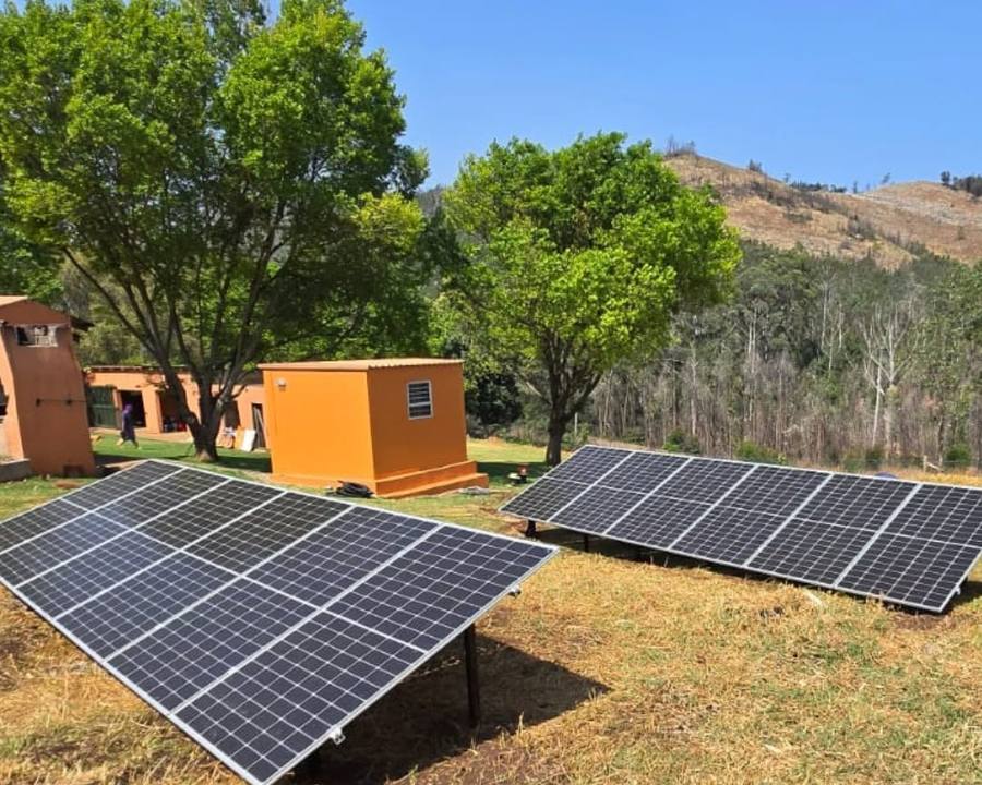 Ground-mounted solar panels on a grassy slope