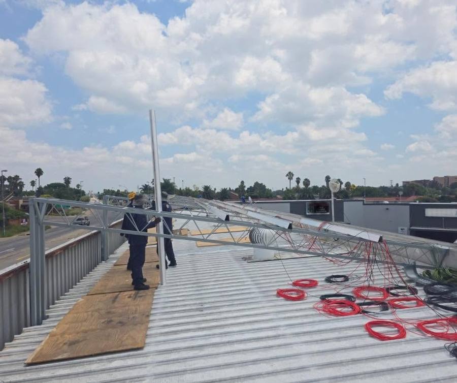 Installer working beside a mounting frame on a roof